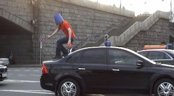 A Crazy Man in Blue Pail Jumps on a Car (7 pics)