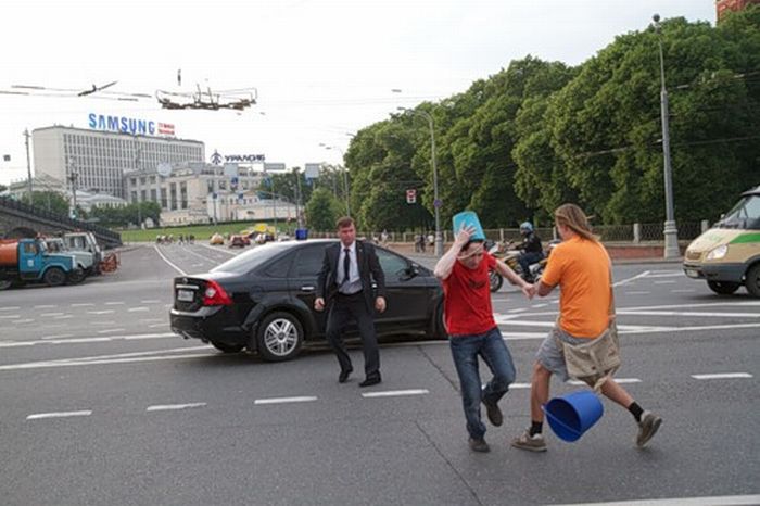 A Crazy Man in Blue Pail Jumps on a Car (7 pics)