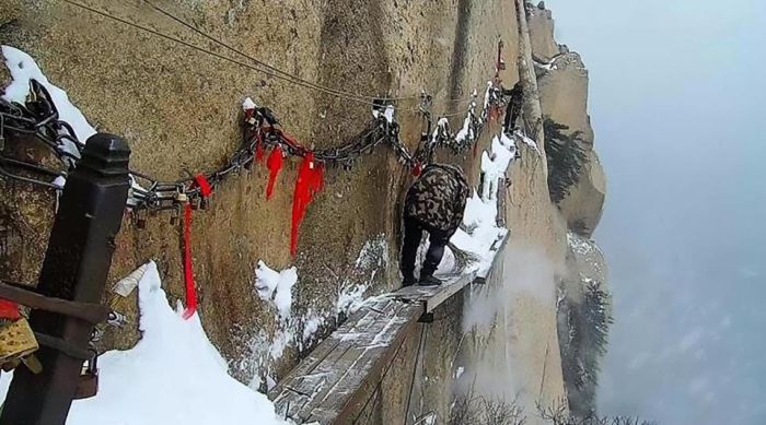 Workers Sweep Snow From A Cliff Path (4 pics)