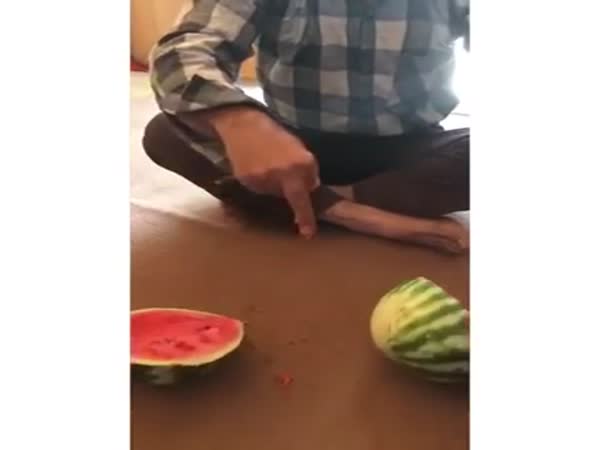 A Guy Cuts A Melon With His Finger